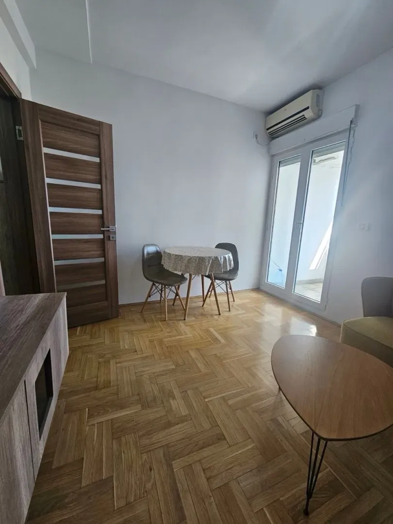 Dnevni boravak sa trpezarijskim stolom i izlazom na terasu.