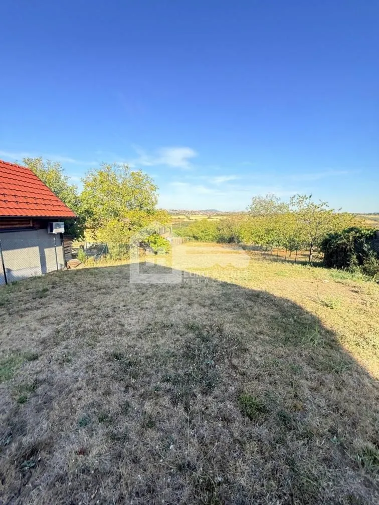 Pogled na dvorište i okolnu prirodu sa pomoćnim objektom.