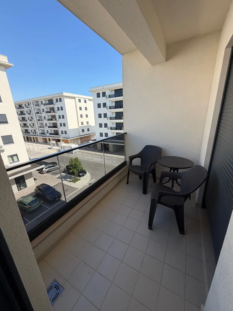 Furnished balcony with seating set and view of the neighborhood.