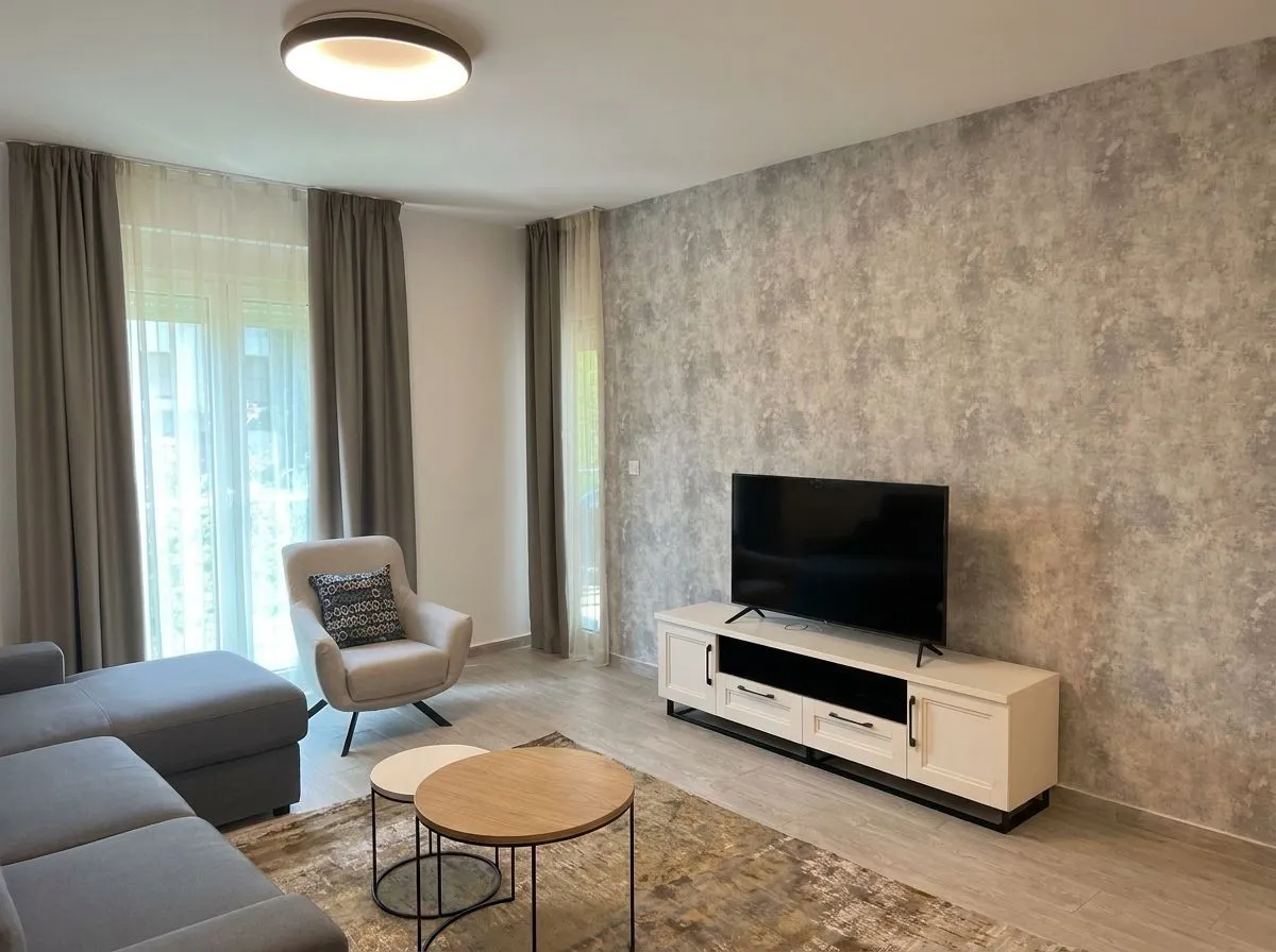Living room with a sofa, armchair, and TV unit.