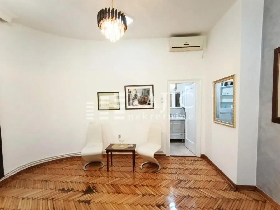 Living room with wooden parquet flooring and a small table with two chairs.