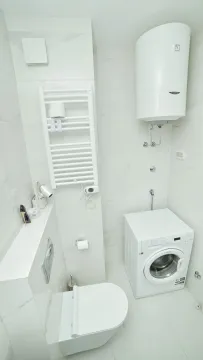 Moderno opremljeno kupatilo sa bijelim pločicama, veš mašinom i bojlerom. - image 6