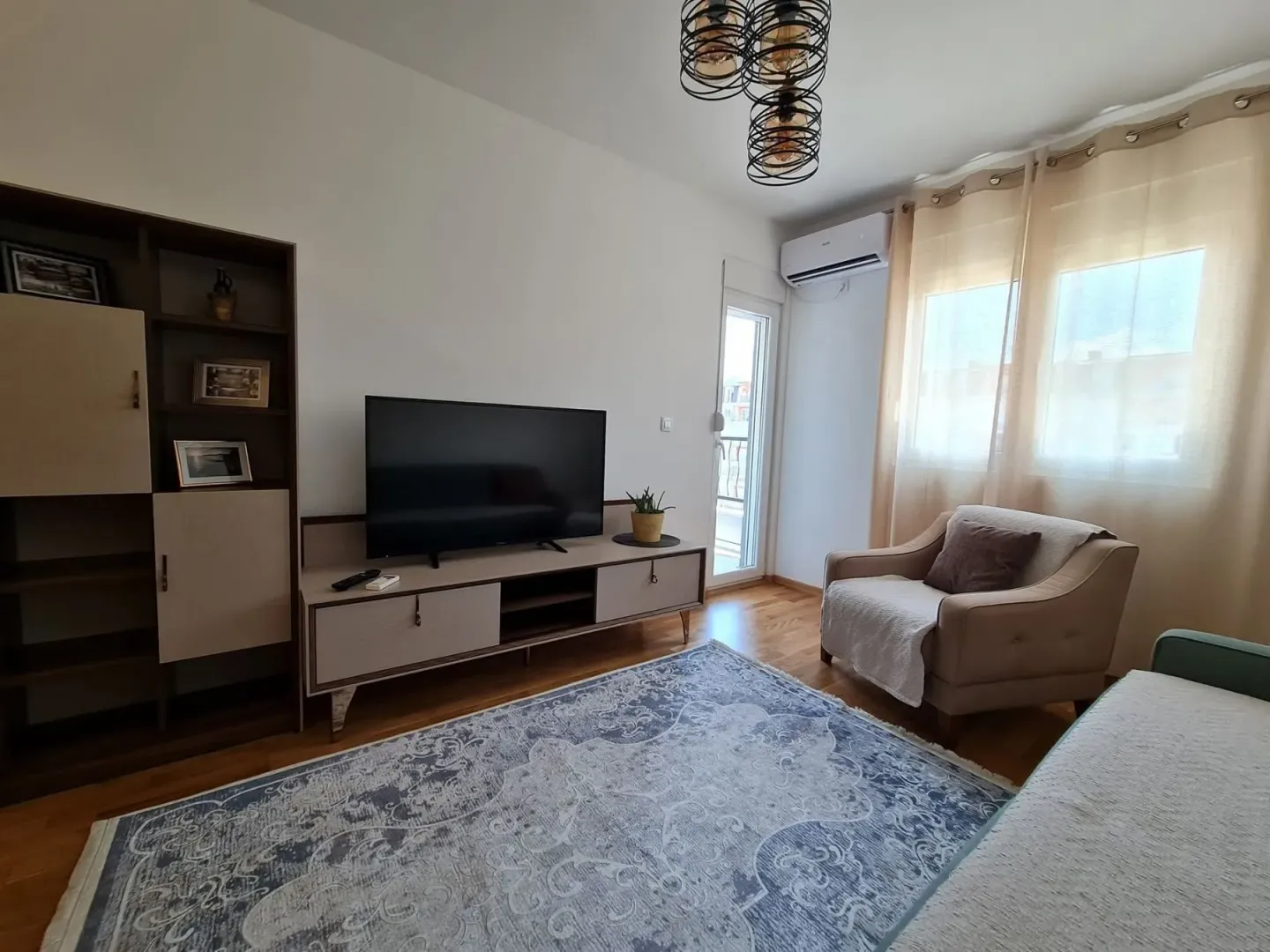 Bright living room with a TV and armchair.