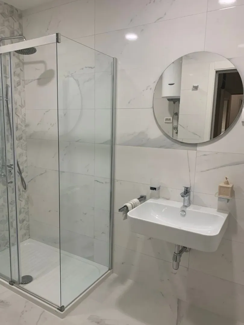 Modernly equipped bathroom with a shower cabin and washbasin.