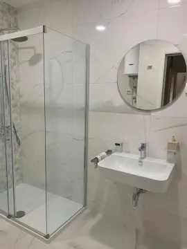 Modernly equipped bathroom with a shower cabin and washbasin. - image 6