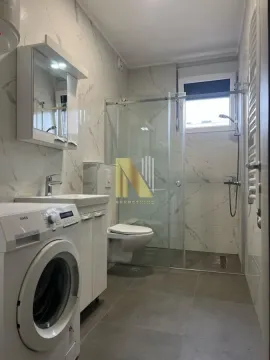 Savremeno opremljeno kupatilo sa tuš kabinom, umivaonikom i veš mašinom. - image 6