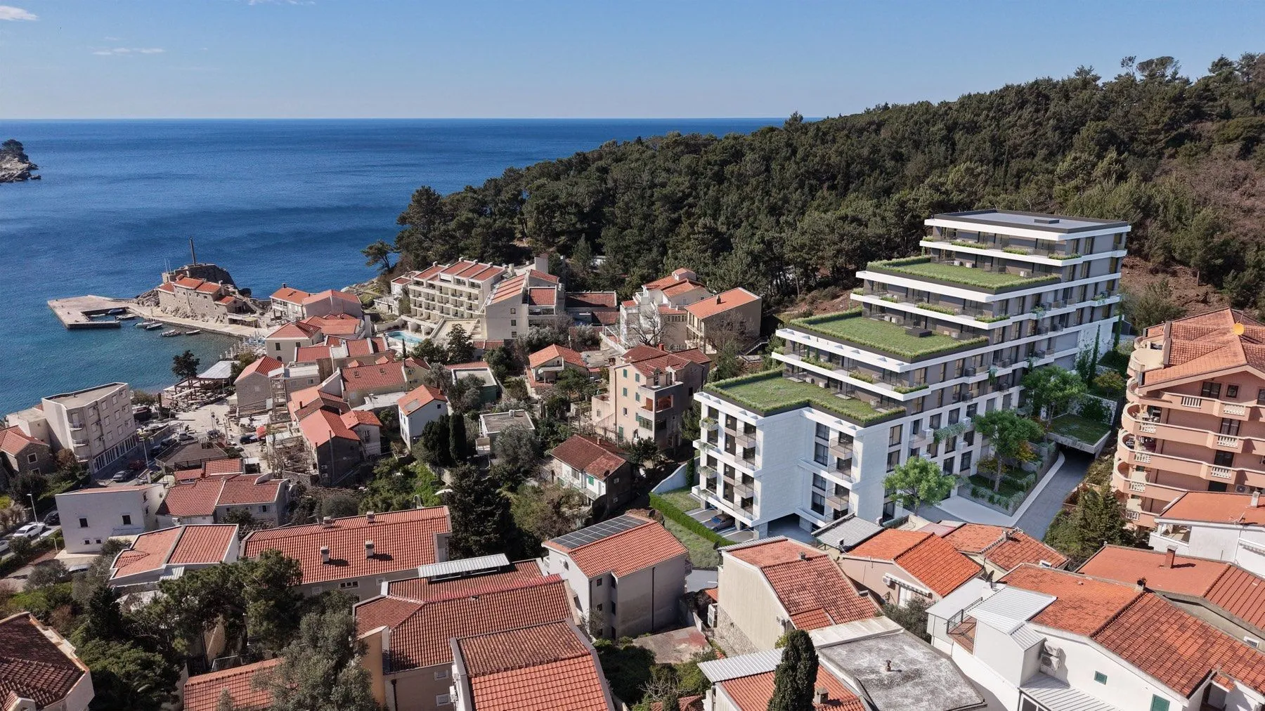 Aerial view of the new building and surrounding neighborhood with sea view.
