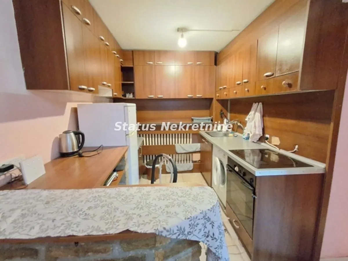 Kuhinja sa drvenim elementima i ugrađenim uređajima.