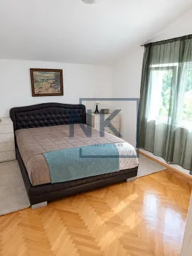 Bedroom with a large bed with a leather headboard, parquet flooring, and a window with curtains. - image 3