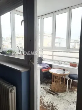 Enclosed balcony with a small table and chairs. - image 17