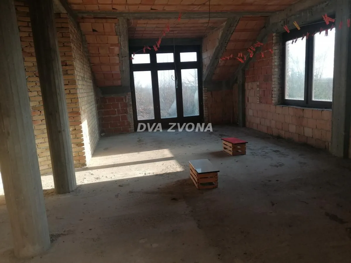 Unfinished room in grey phase construction with windows.