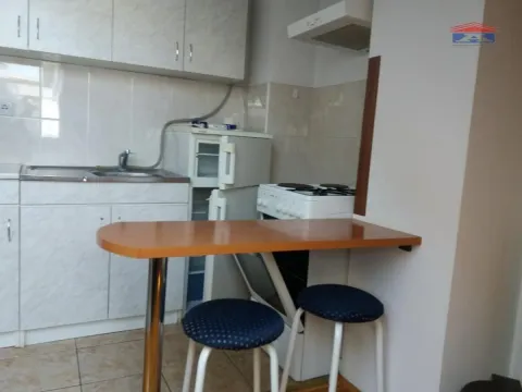 Manja kuhinja sa elementima, frižiderom, šporetom i šankom sa dve stolice. - image 4