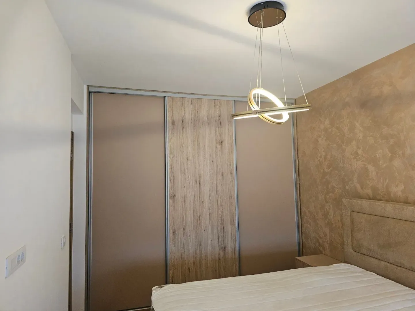 Spavaća soba sa velikim ugradnim garderoberom i bračnim krevetom.