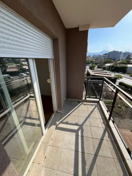 Natkriveni balkon sa popločanim podom i staklenom ogradom, sa pogledom na ulicu. - image 4
