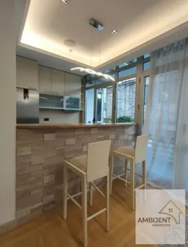 Kitchen with a bar counter and bar stools. - image 7