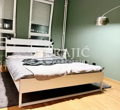 Furnished bedroom with a white bed and a green wall. - image 10