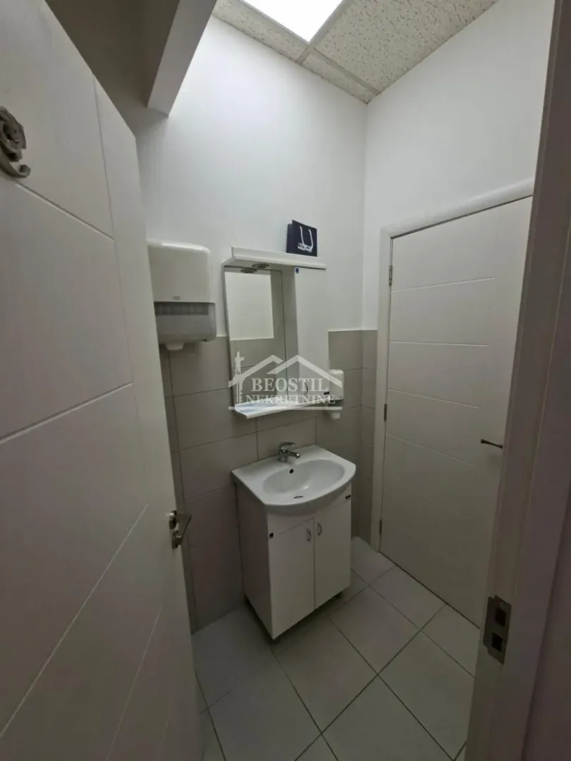 Smaller bathroom with a sink, mirror, and tiles.