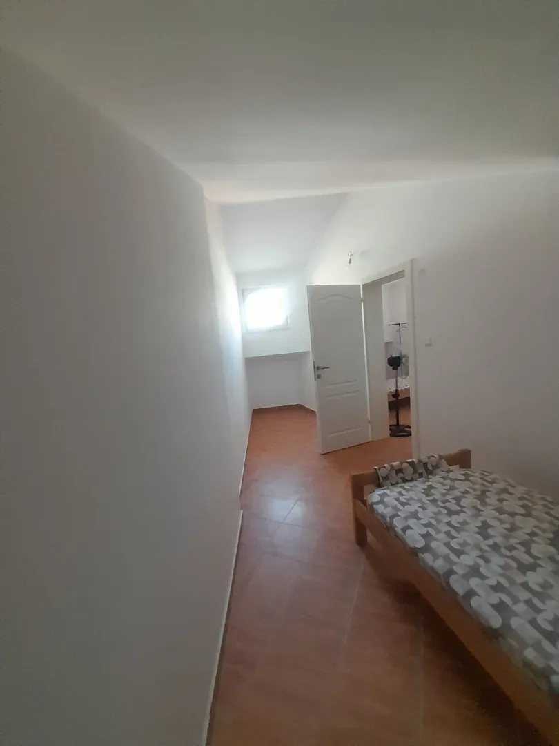 Smaller bedroom with a bed and tiled floor.