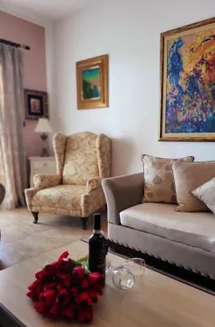 Udoban dnevni boravak sa garniturom, foteljom i umjetničkim slikama na zidu. - image 3