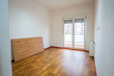 Prazna soba sa svijetlim zidovima, laminatom i izlazom na balkon. - image 9