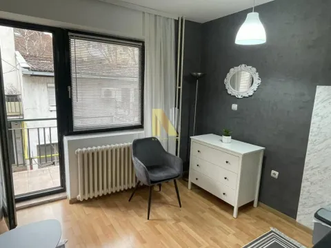 Dnevna soba sa sivim zidom, belom komodom i izlazom na terasu. - image 7