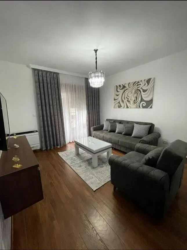 Dnevna soba sa garniturom, stočićem i TV komodom.