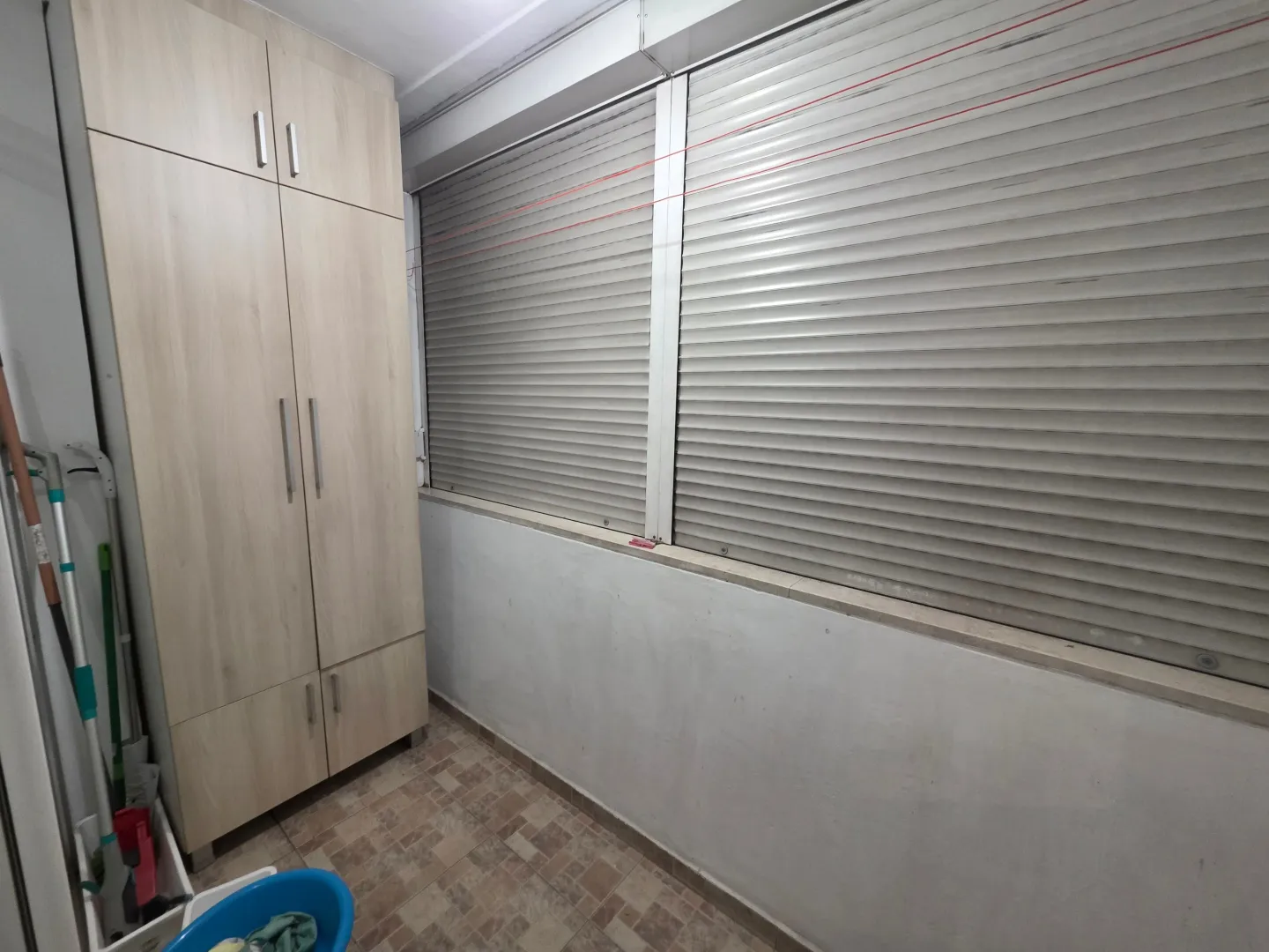 Zastakljena terasa sa ugrađenim plakarom i keramičkim podom.