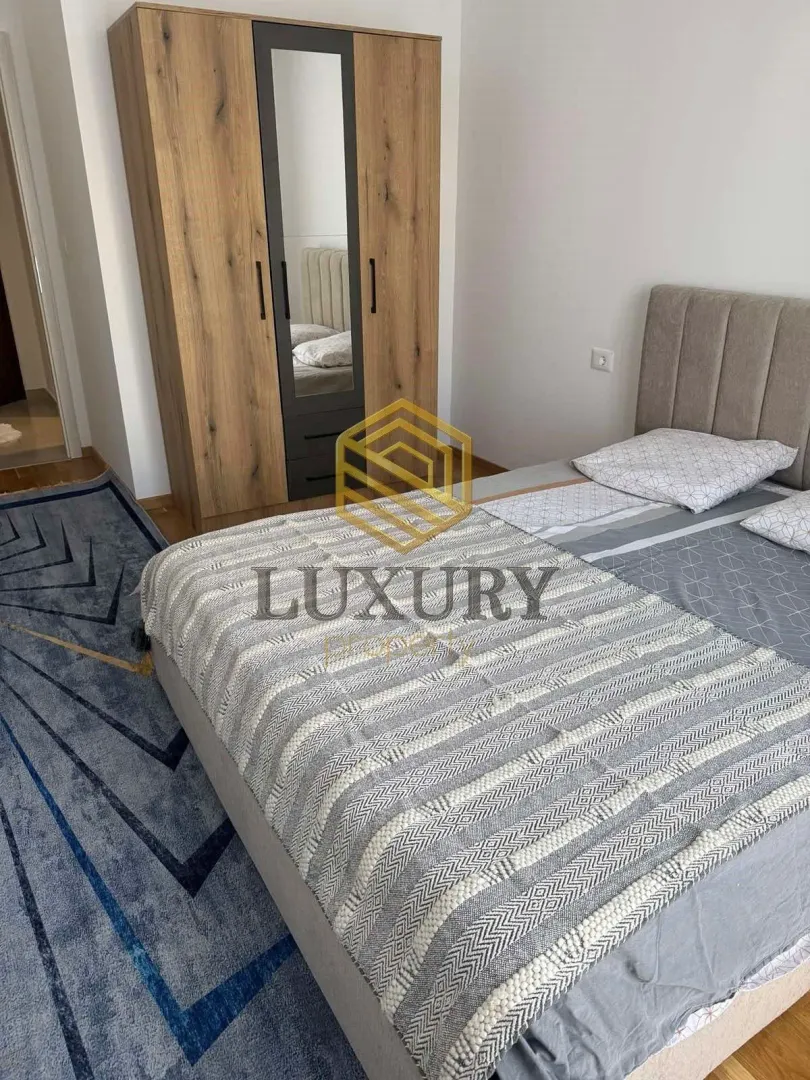 Furnished bedroom with a double bed and a wardrobe.