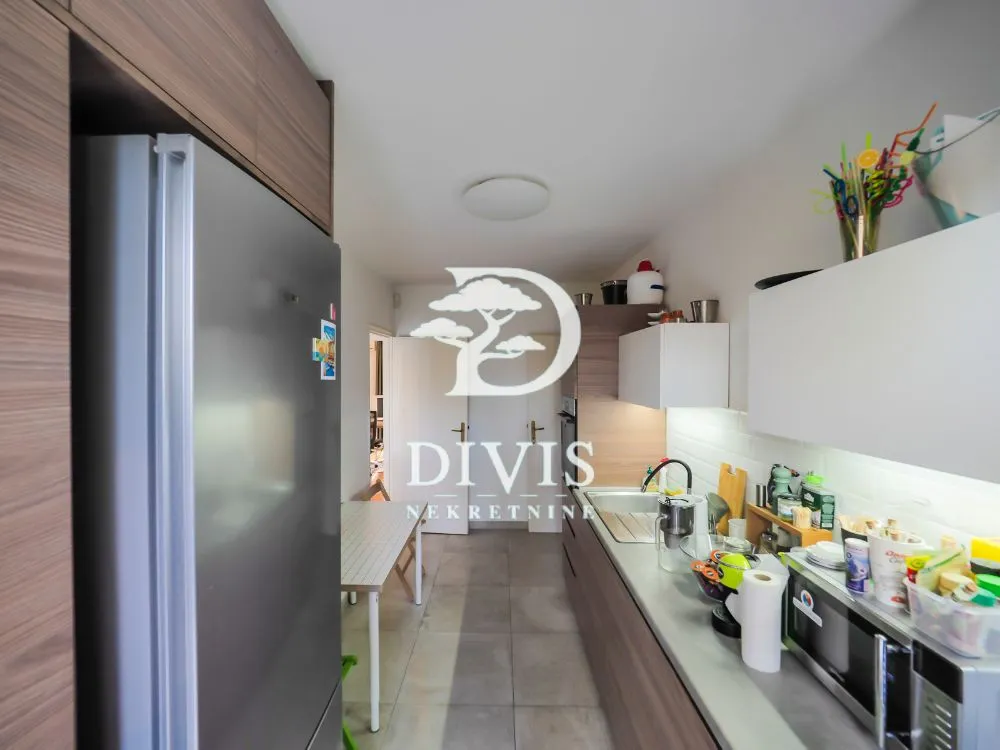 Compact kitchen with a refrigerator and a dining table.