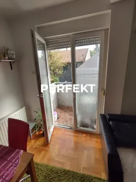 Dnevna soba sa izlazom na balkon i drvenim podom. - image 10