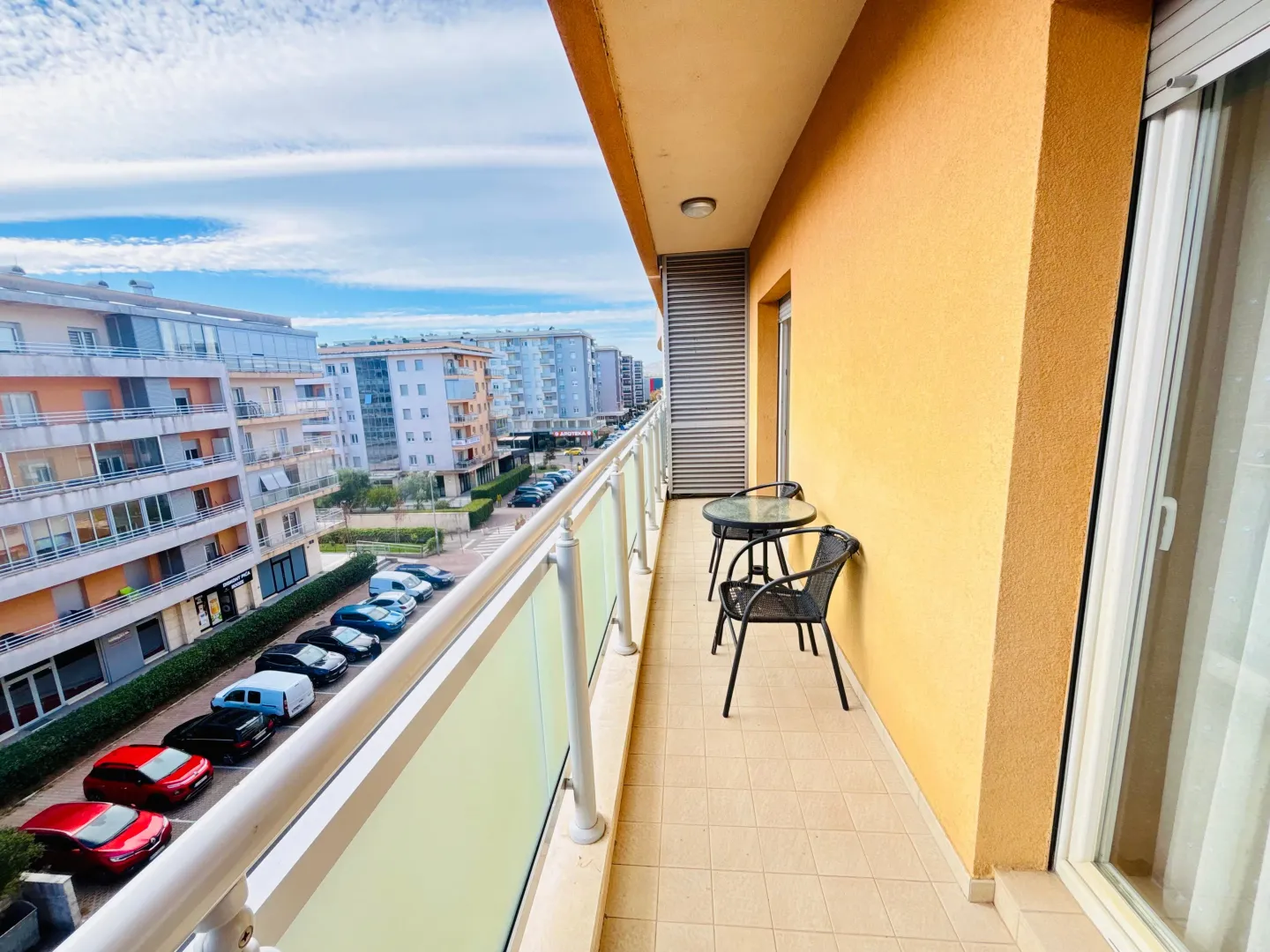Natkriveni balkon sa garniturom za sjedenje i pogledom na grad.