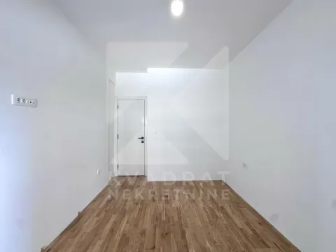 Prazna prostorija sa bijelim zidovima i drvenim podom. - image 6