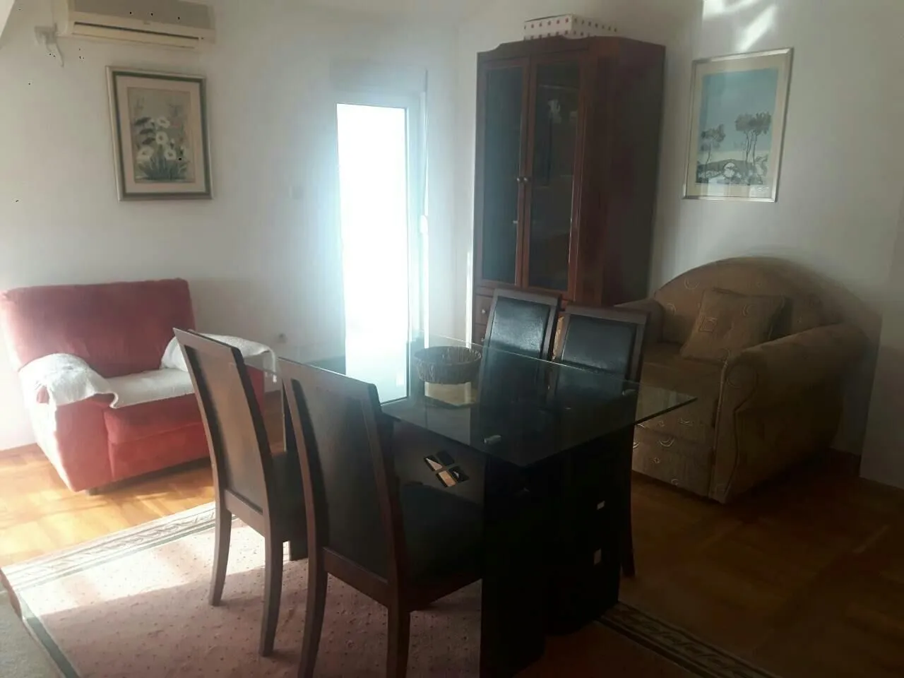 Svijetla dnevna soba sa trpezarijskim stolom i garniturom za sjedenje.