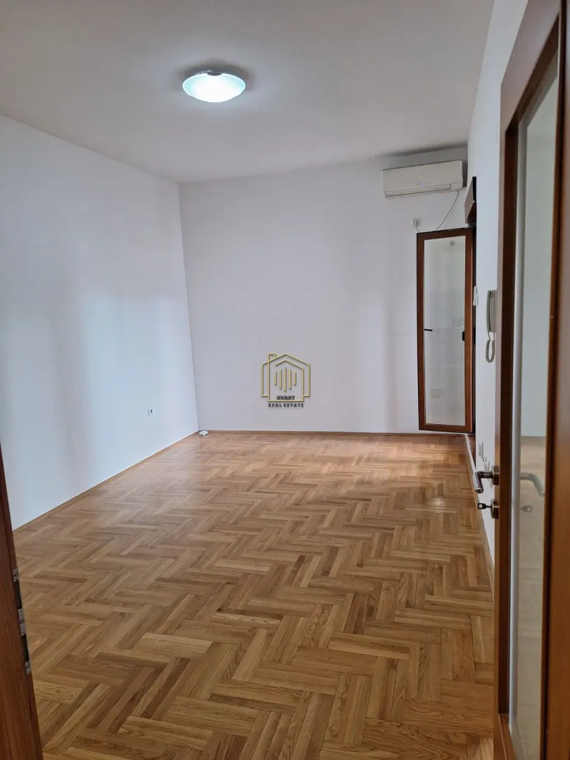 Empty room with parquet flooring and white walls.