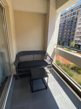 Balkon sa pletenom garniturom za sjedenje i malim stolom. - image 17