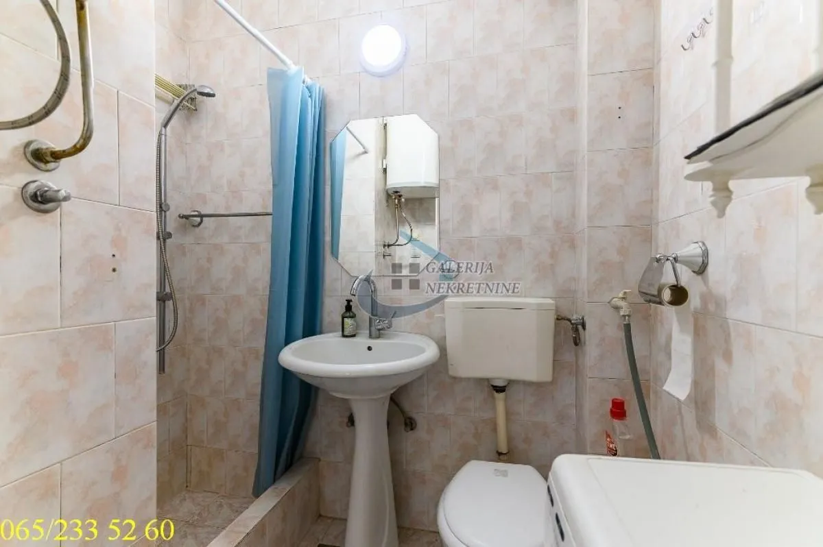 Kupatilo opremljeno tuš kabinom, umivaonikom, wc šoljom i bojlerom.