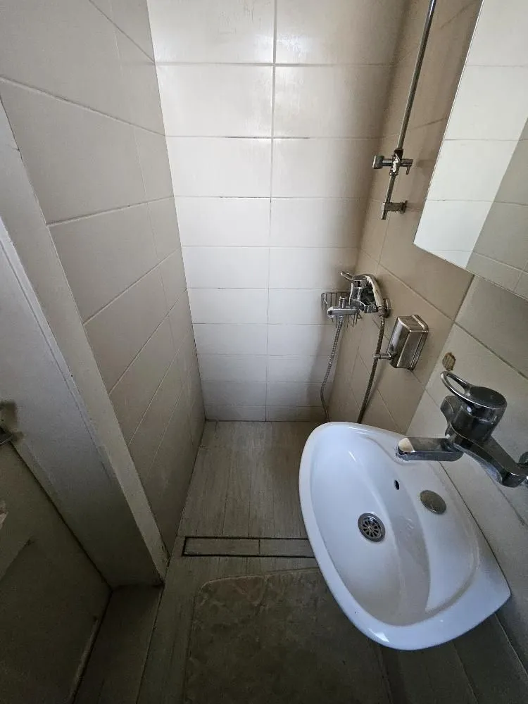 Manje kupatilo sa tuš kabinom i umivaonikom.