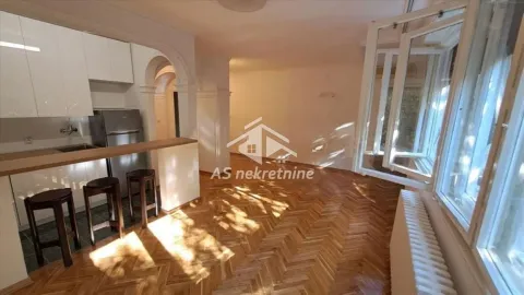 Kitchen with a breakfast bar and wooden flooring in an apartment. - image 2
