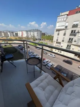 Namješten balkon sa stolicama i pogledom na ulicu i zgrade. - image 9