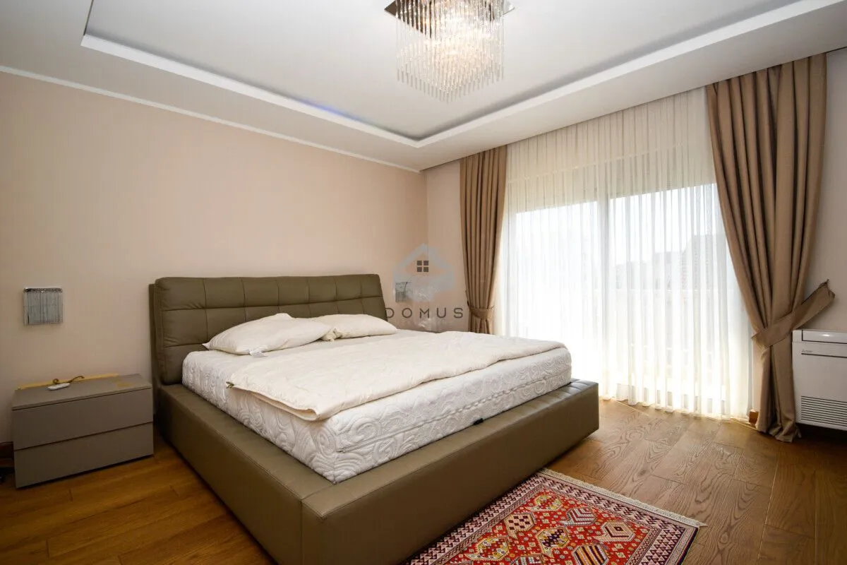 Spacious bedroom with a double bed, wooden flooring, and terrace access.