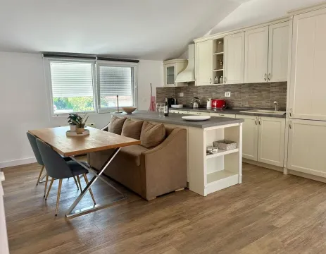 Bright kitchen with dining area and built-in kitchen units. - image 3