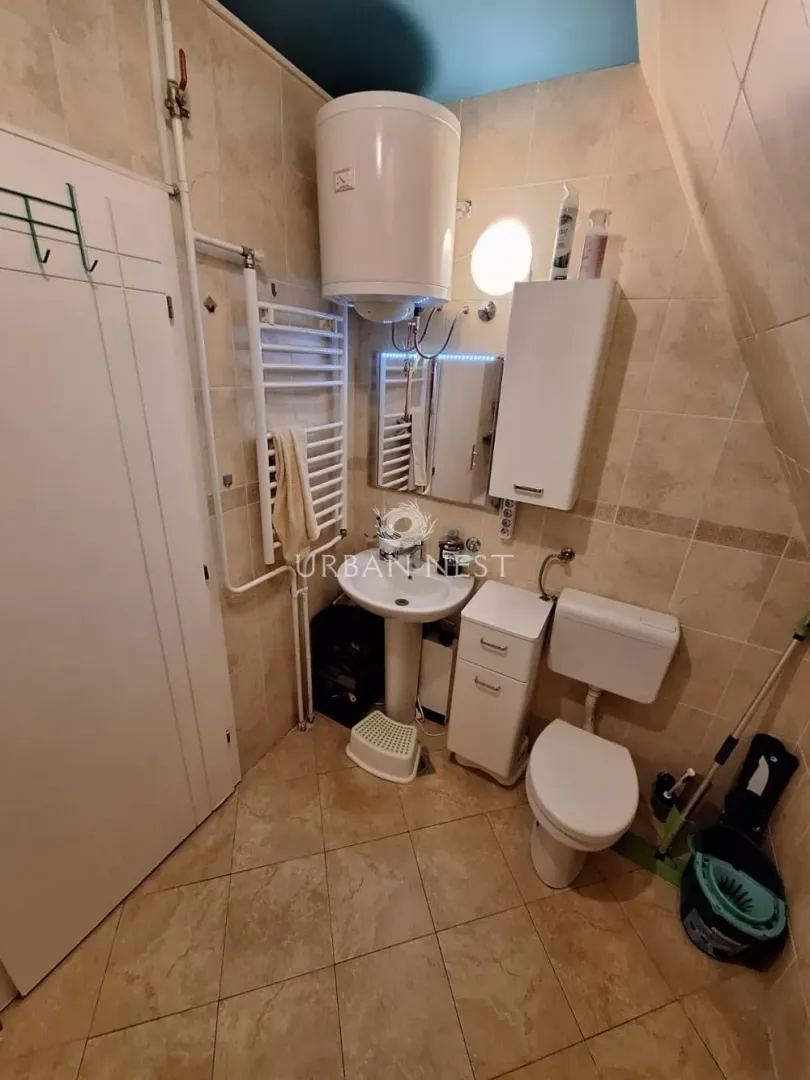Manje kupatilo obloženo keramičkim pločicama sa toaletom, umivaonikom i bojlerom.