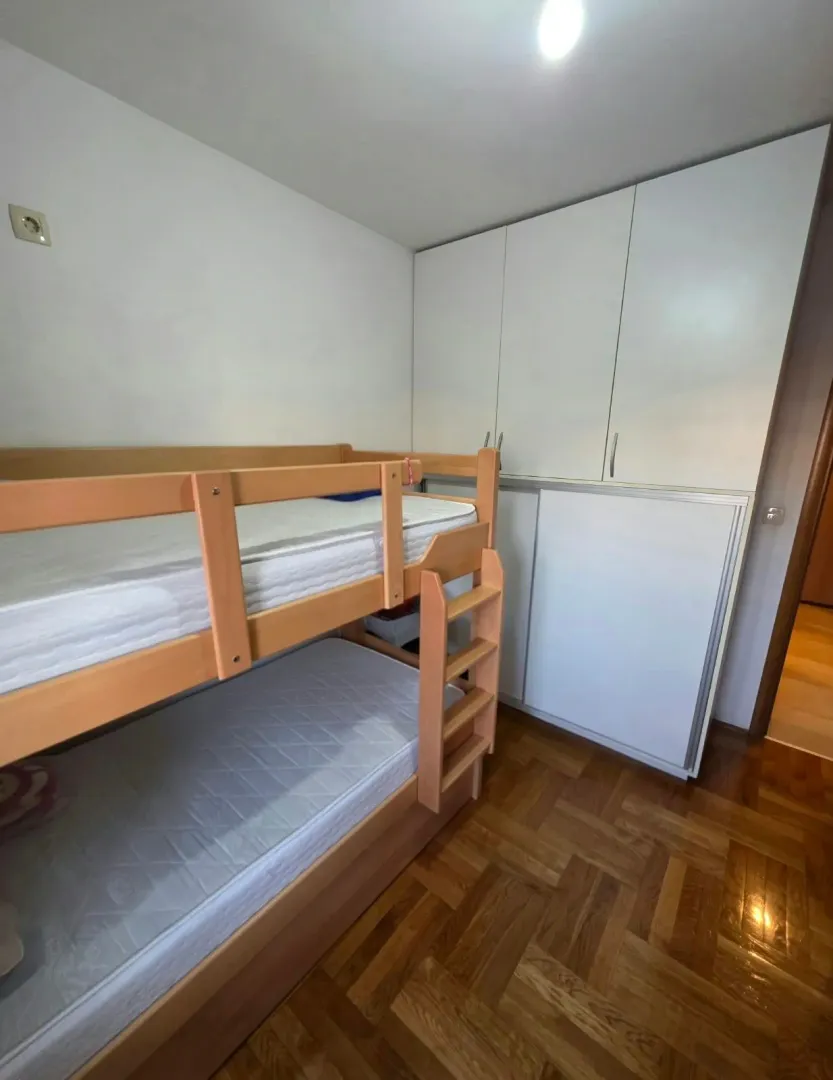 Dječija soba sa krevetom na sprat i ugradnim ormarom.
