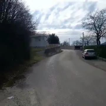 Asfaltni put koji vodi prema naselju sa kućama i zelenilom. - image 9