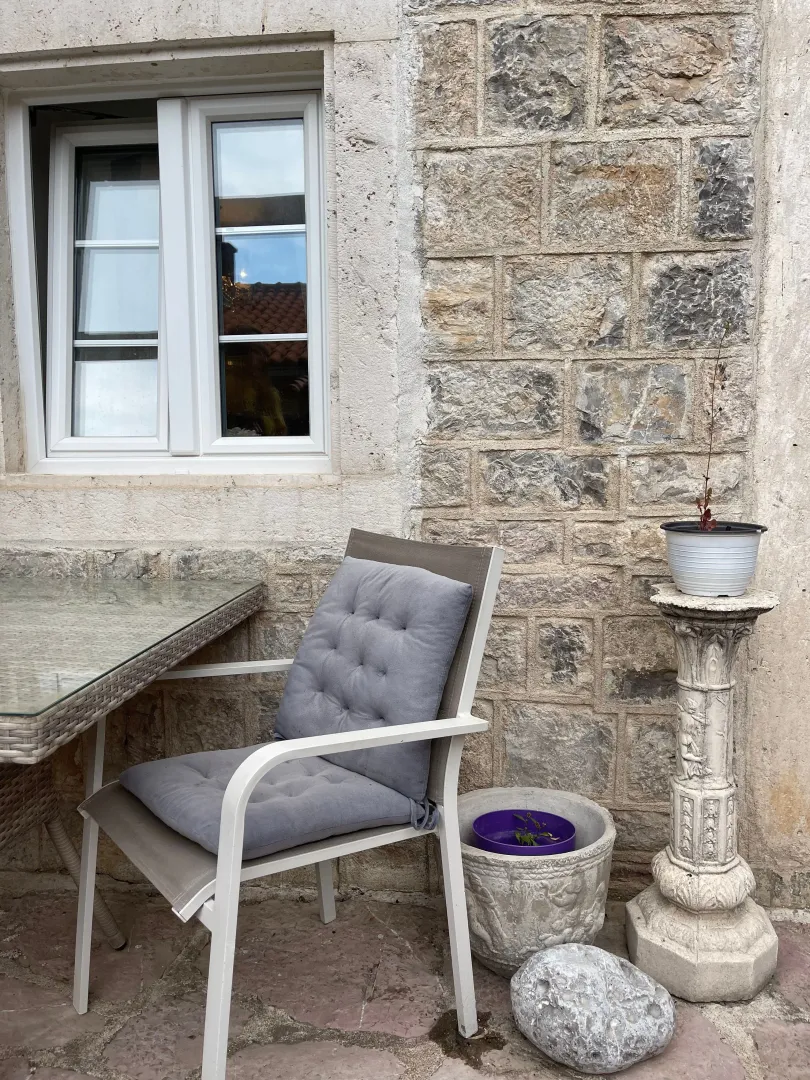 Terrace with a table, chair, and a stone wall.