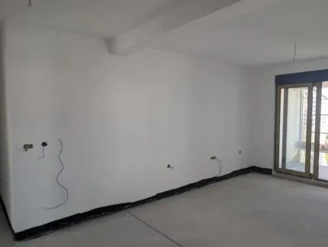 Prazna prostorija sa bijelim zidovima i balkonskim vratima u izgradnji. - image 11