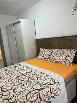 Svijetla spavaća soba sa bračnim krevetom i bijelim ormarom. - image 4