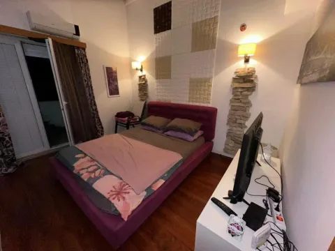 Namještena spavaća soba sa bračnim krevetom, televizorom i izlazom na terasu. - image 6