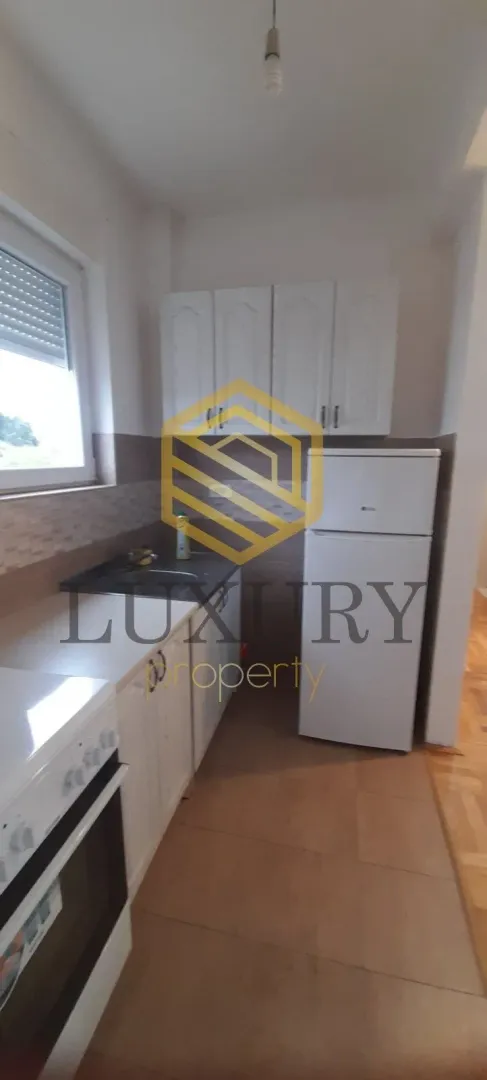Small white kitchen with a refrigerator and stove.