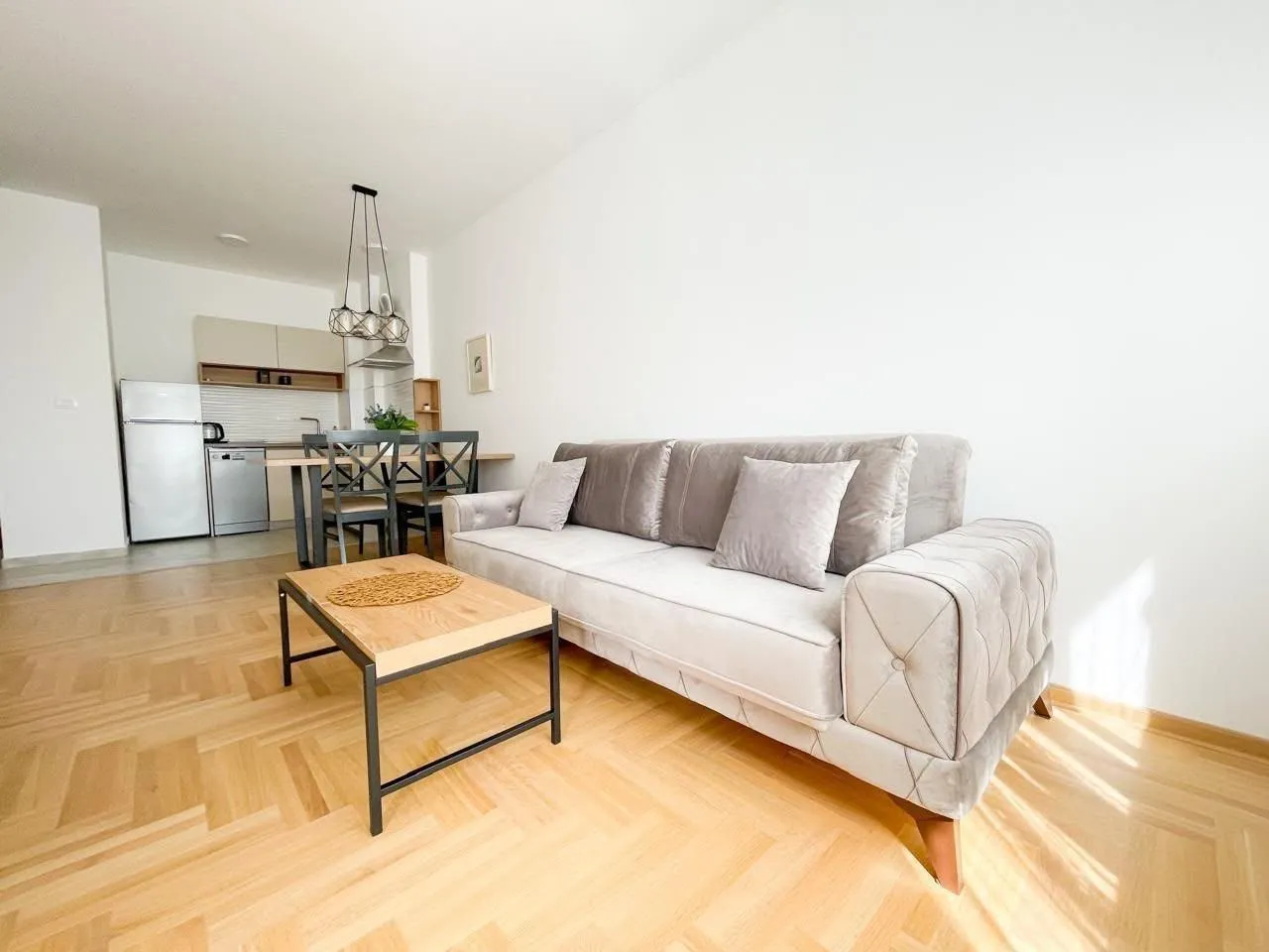 Bright living room with sofa and dining area in the background.